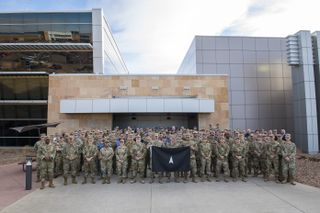 Members of the 392d Combat Training Squadron stand with SPACE FLAG 23-1 participants for a group photo at Schriever Space Force Base, Colorado, Dec. 5, 2022.