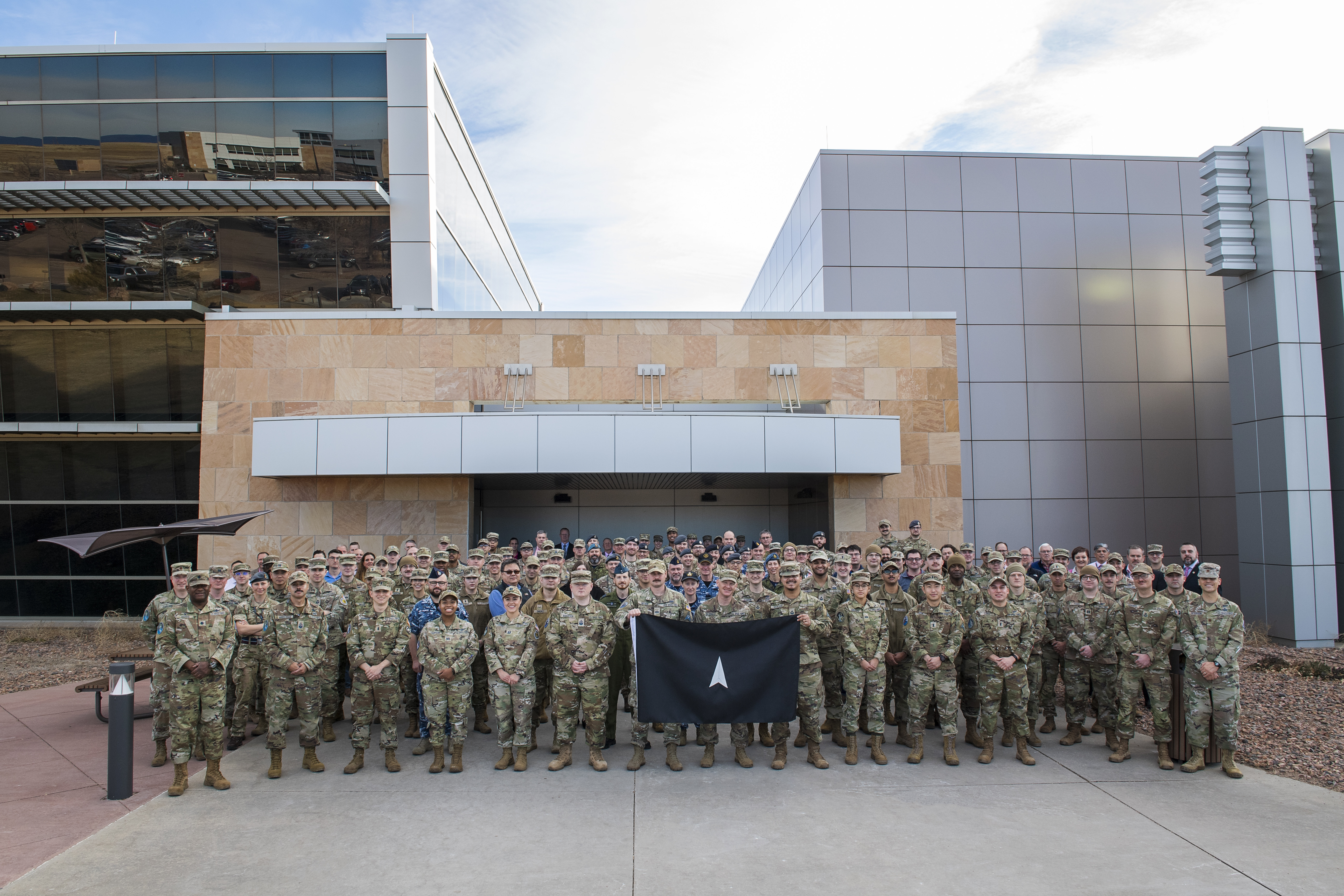 Members of the 392d Combat Training Squadron stand with SPACE FLAG 23-1 participants for a group photo at Schriever Space Force Base, Colorado, Dec. 5.  2022.