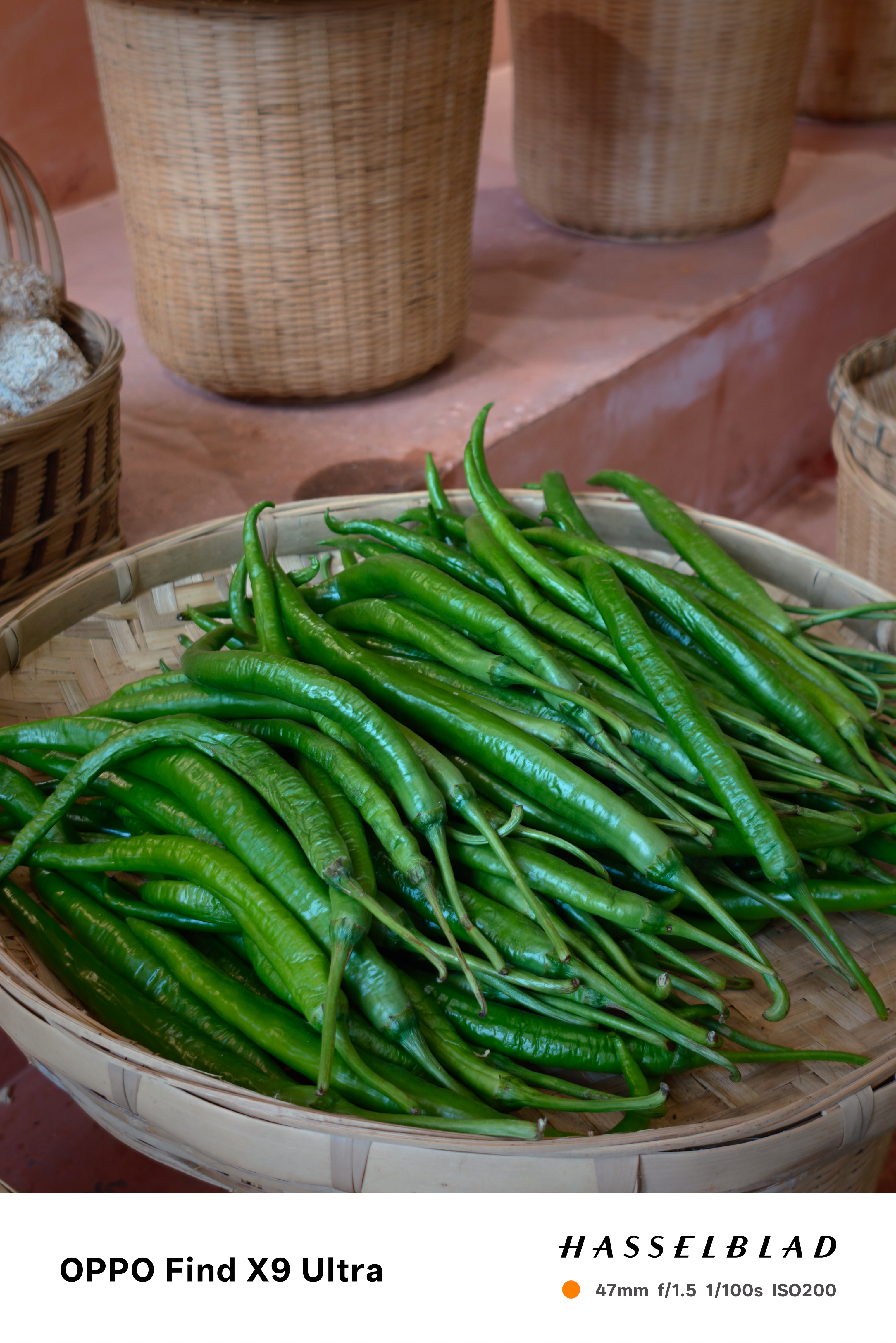 Basket piled with fresh green chilies in an indoor market