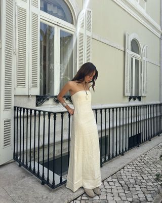 an influencer wearing a maxi dress and pendant necklace