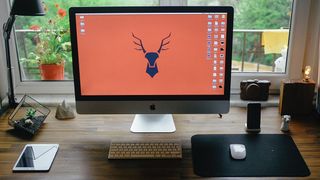 iMac on a desk by the window at home