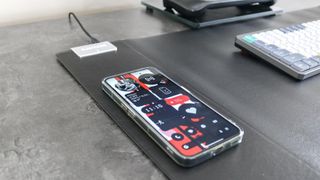A phone charging on the Magic Mat Pro's wireless charger