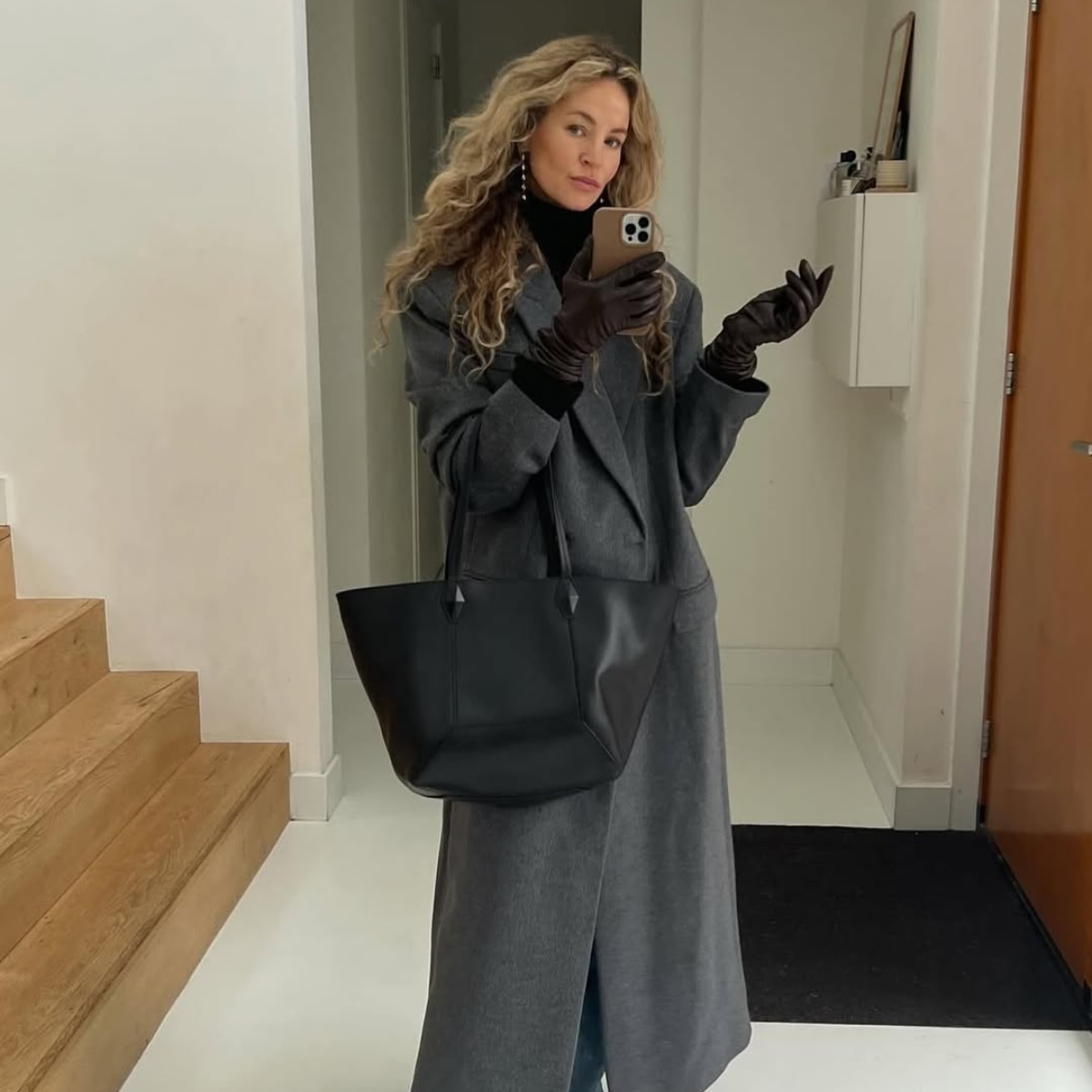 @anoukyve wears grey coat, black gloves, black bag