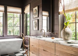 Farmhouse bathroom with dark brown panelled walls, light wooden units and marble counter