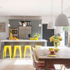 kitchen with white wall and counter and yellow stools