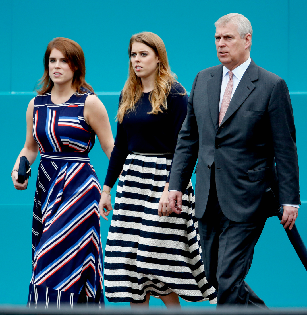 Princess Eugenie, Princess Beatrice and Prince Andrew walking in a row in front of a teal wall