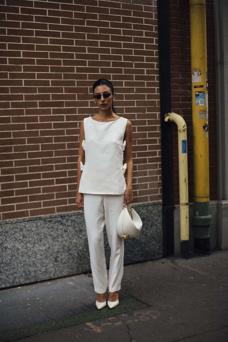 woman wearing a white vest and cropped pants