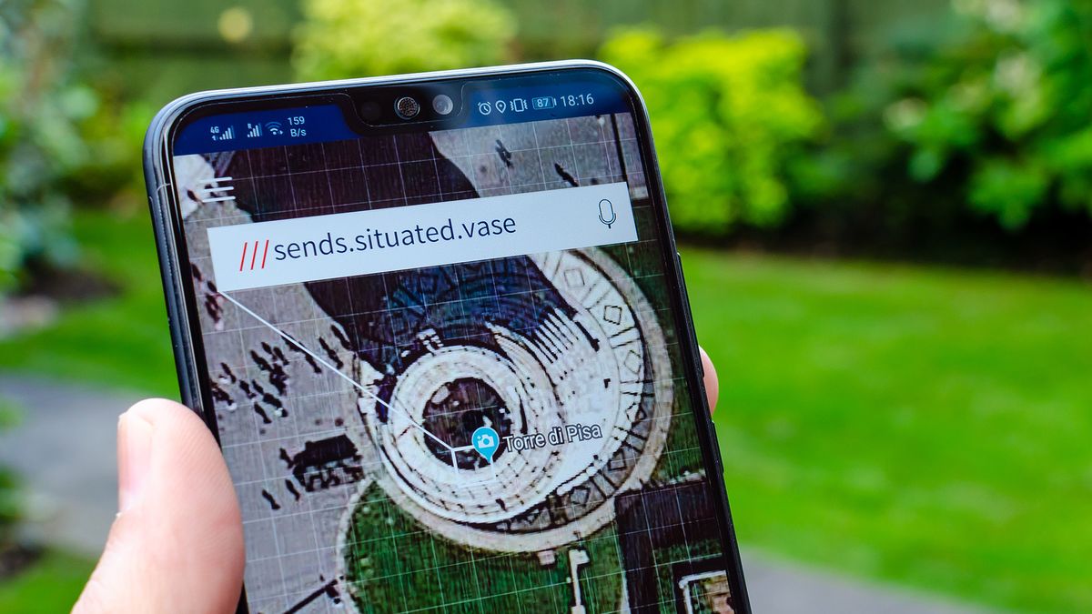 A person&amp;#039;s hand holding a smartphone that has What3Words open showing the co-ordinates for the Leaning Tower of Pisa