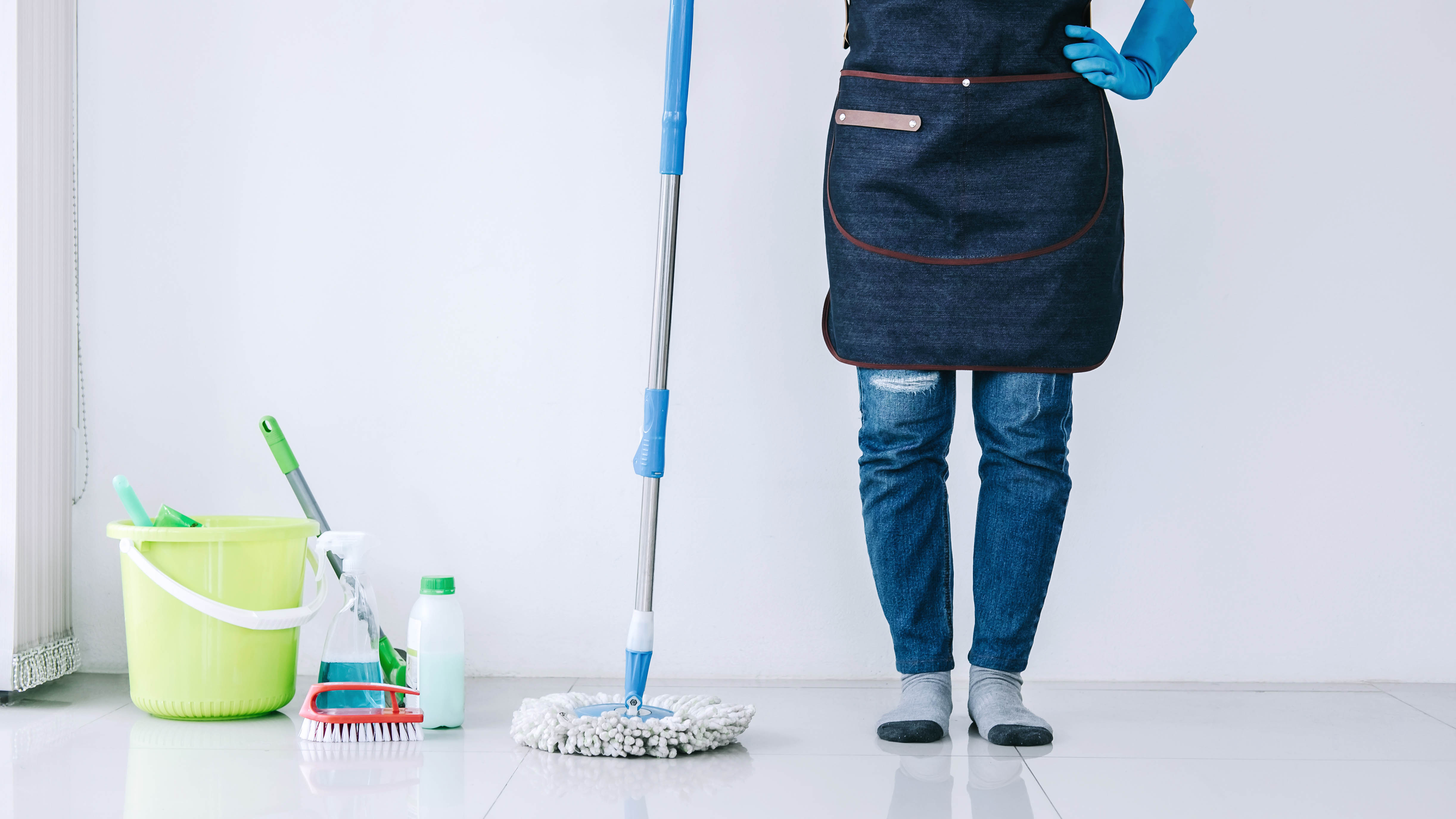 A professional cleaner next to a mop and bucket