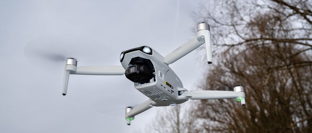 Ruko F11PRO 2 drone flying in front of trees and a grey cloudy sky