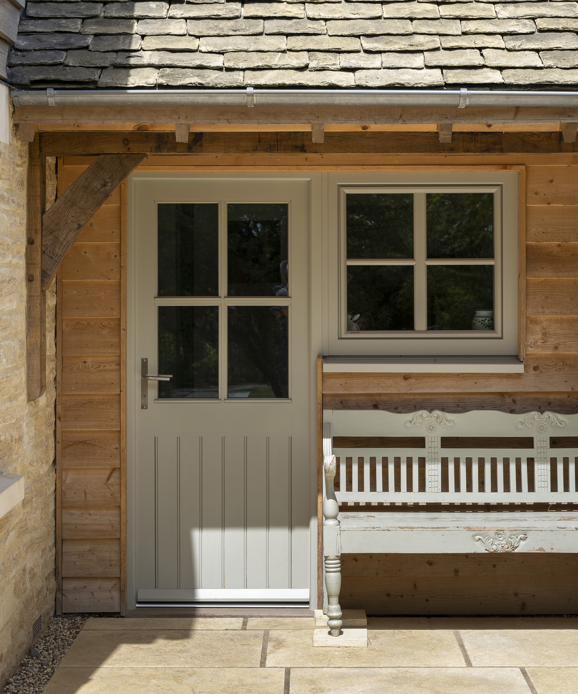 A farmhouse style back door with a bench seating next to it