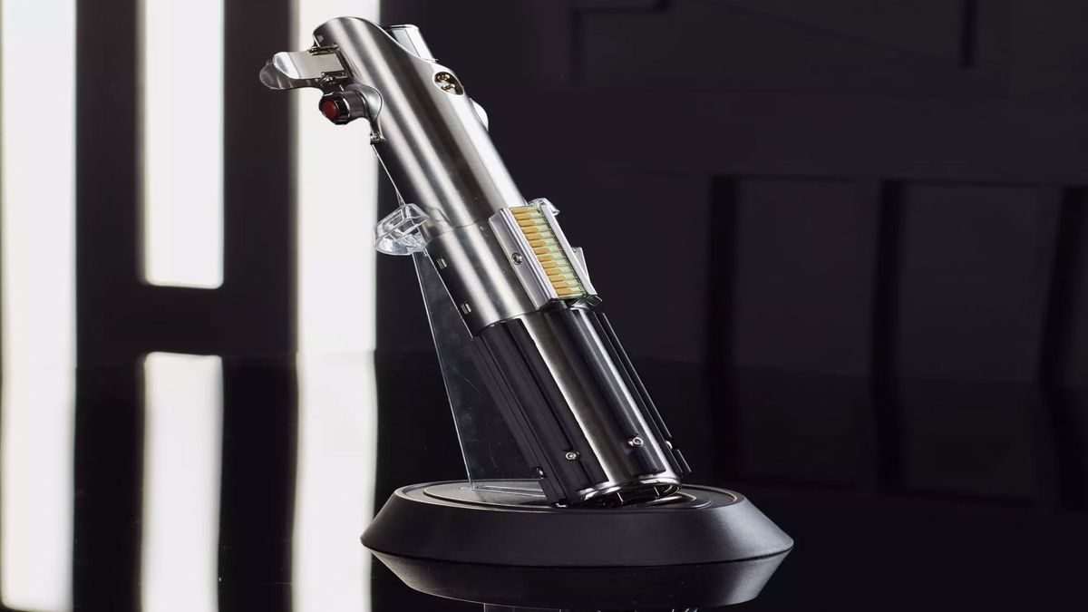 A silver metal hilt is on display as a blue lightsaber is on a black background.