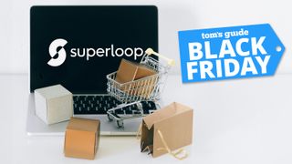 Superloop logo on laptop screen background with tiny shopping cart and brown gift bags on keyboard of laptop and Tom&#039;s Guide Black Friday blue badge on top right corner