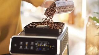 One of the best coffee makers, the Philips 3200, being filled from the top with coffee beans