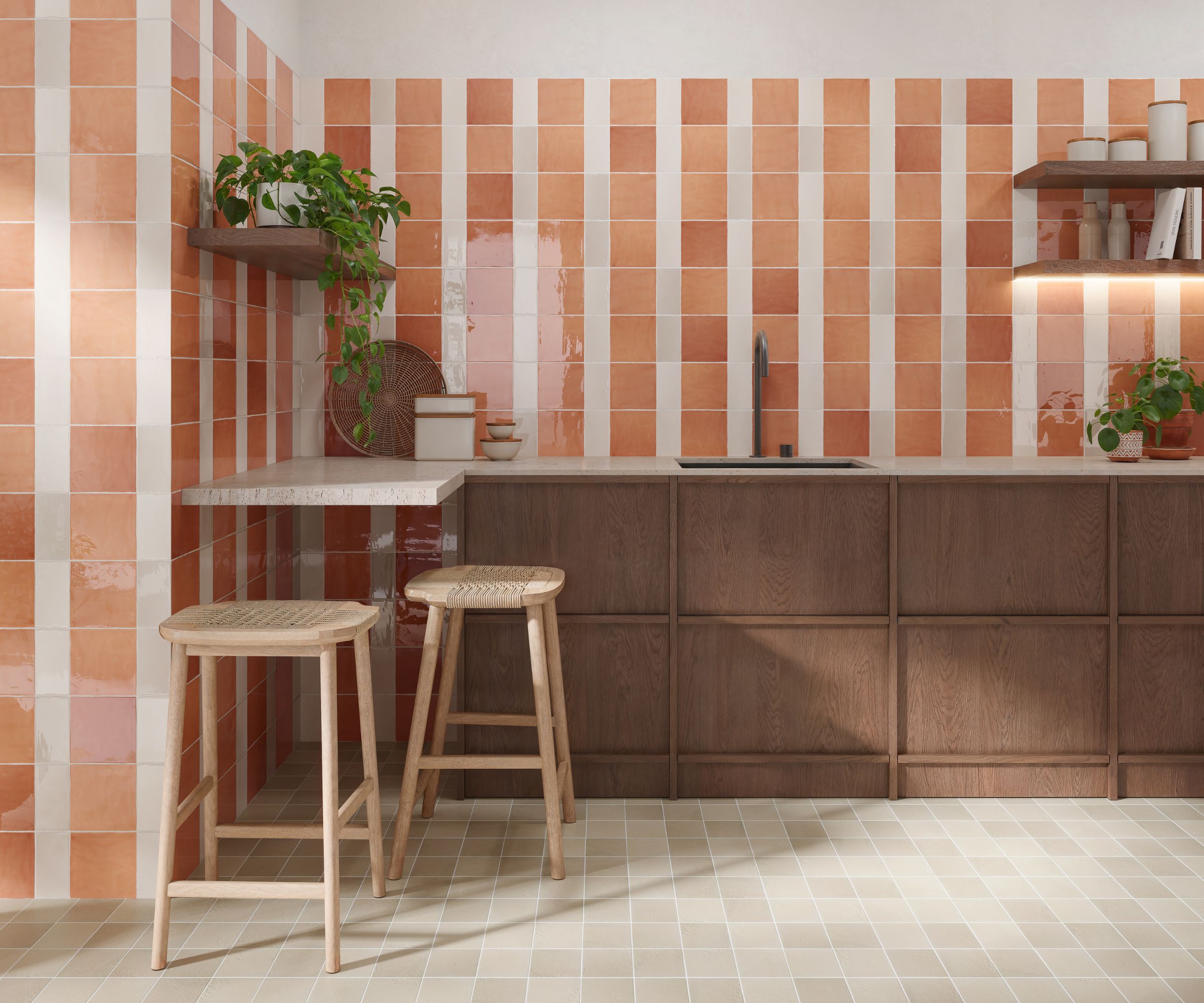A kitchen with terracotta and white vertical stripe wall tiles, small square floor tiles, dark wood cabinetry and two wooden bar stools.