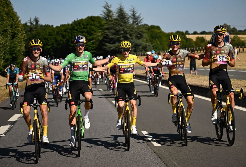 TOPSHOT From L JumboVisma teams Belgian rider Tiesj Benoot holding the bib number of absent teammate JumboVisma teams Belgian rider Nathan Van Hooydonck JumboVisma teams Belgian rider Wout Van Aert wearing the sprinters green jersey JumboVisma teams Danish rider Jonas Vingegaard wearing the overall leaders yellow jersey JumboVisma teams American rider Sepp Kuss holding the bib number of absent teammate JumboVisma teams Slovenian rider Primoz Roglic and JumboVisma teams French rider Christophe Laporte holding the bib number of absent teammate JumboVisma teams Dutch rider Steven Kruijswijk cycle during the 21st and final stage of the 109th edition of the Tour de France cycling race 1156 km between La Defense Arena in Nanterre outside Paris and the ChampsElysees in Paris France on July 24 2022 Photo by Marco BERTORELLO AFP Photo by MARCO BERTORELLOAFP via Getty Images