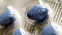 Close-up photo of blue pills of Viagra in a silver pill packet with Pfizer written on them