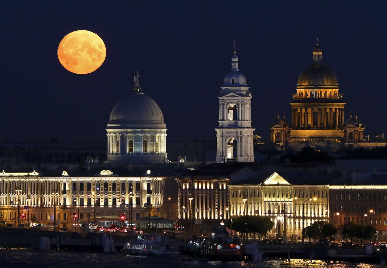 The full moon shines over the Church of St Catherine (left) and St Isaac's Cathedral in St. Petersburg, Russia, on Aug. 21, 2021.