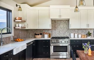 Full backsplash in gray chevron tiles below cream kitchen cabinets