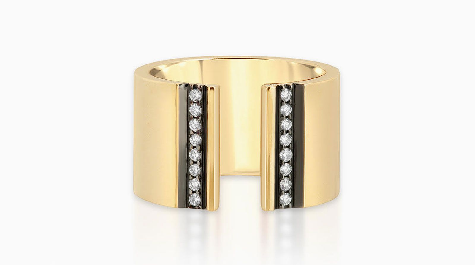 Nancy newberg taps ring is a large gold band with black trim and diamond sto<em></em>nes parallel from one edge to the other.