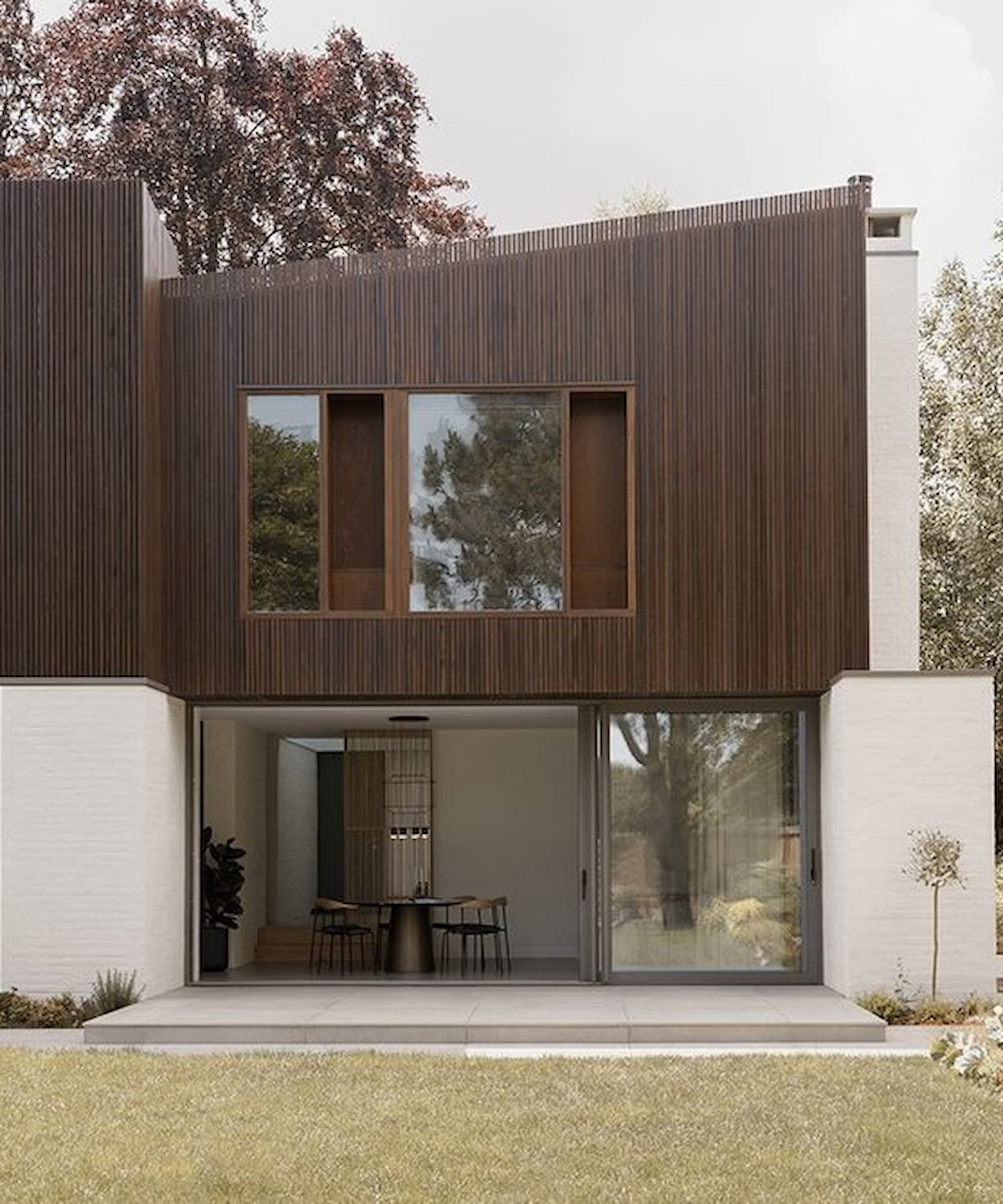 The rear of a self build with wooden exterior and bifold doors downstairs and sliding windows upstairs