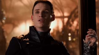 Eddie Redmayne sits looking aloof with a hand in the air in Jupiter Ascending.