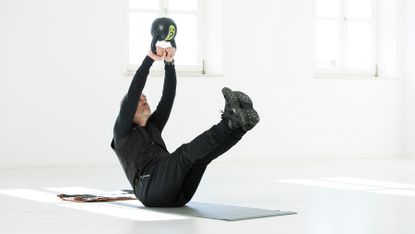 Man uses a kettlebell in a core based workout