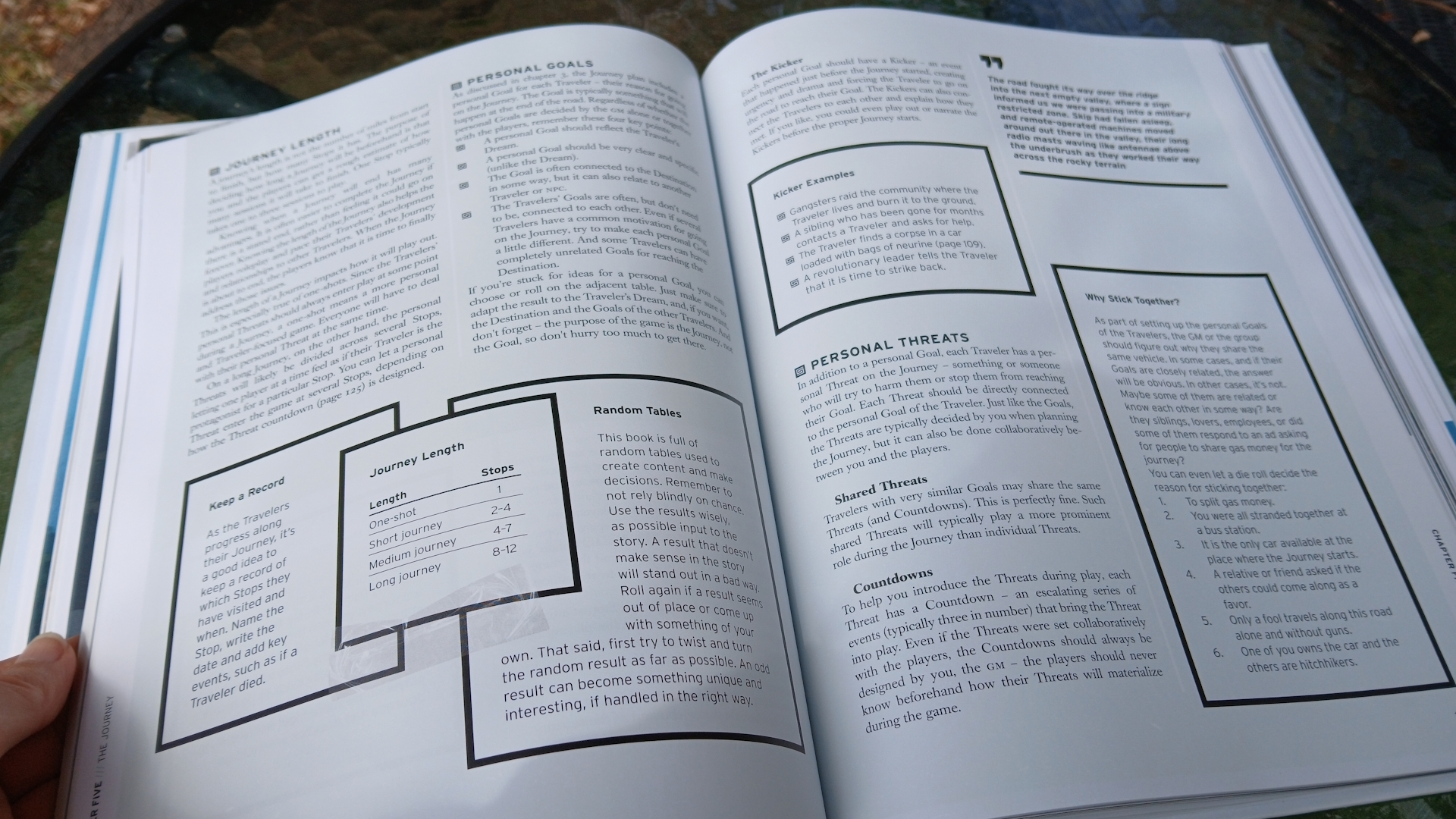 A hand holding the open Electric State rulebook