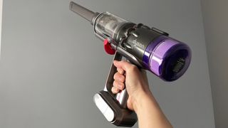 Dyson Micro 1.5kg being used as a handheld vacuum cleaner to clean up high