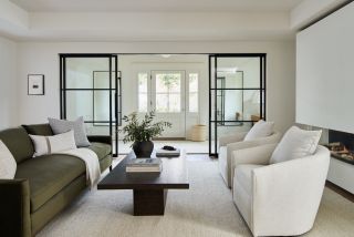 living room with dark green sofa and white armchairs, off white walls