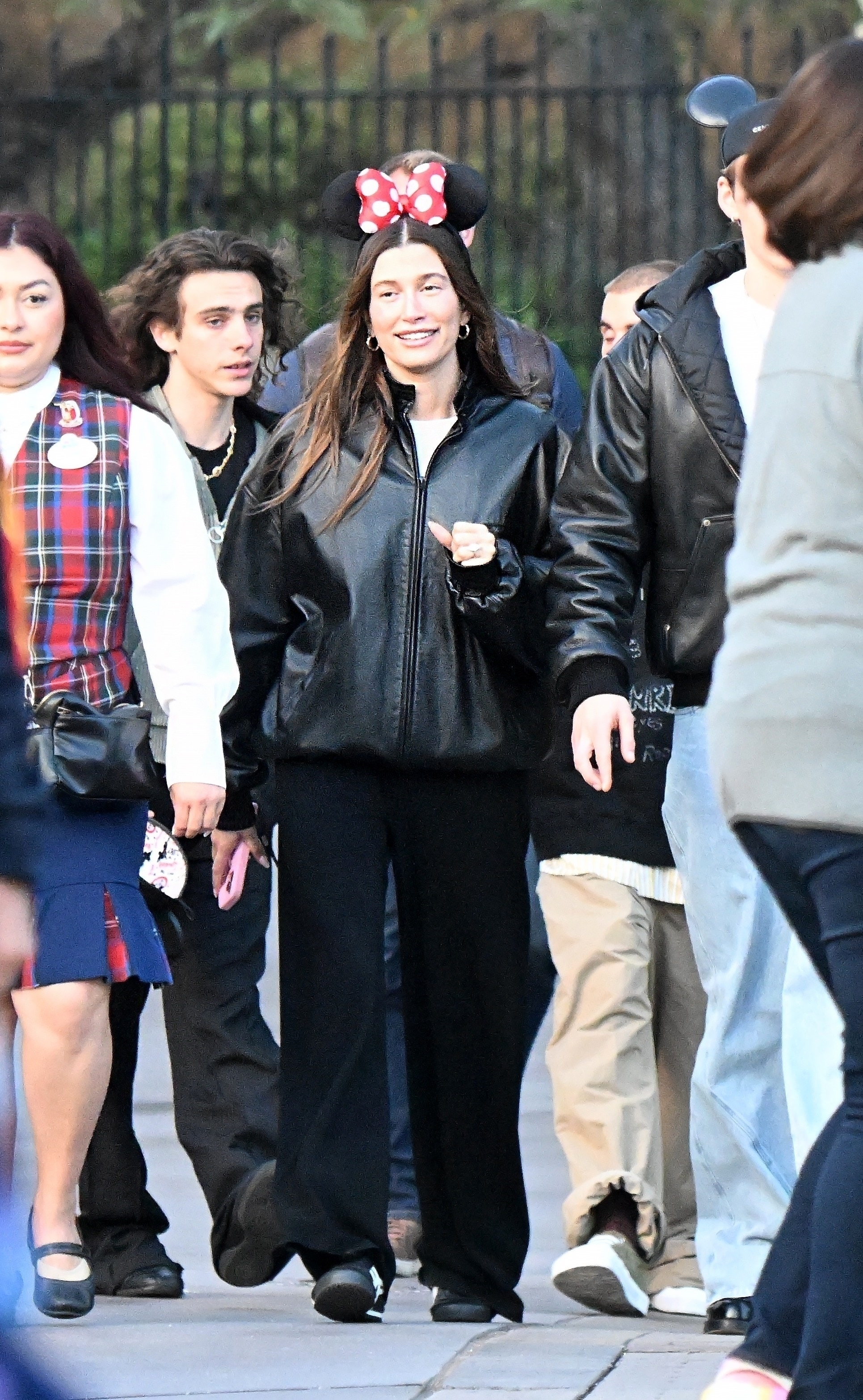 Hailey Bieber at Disneyland wearing a black jacket and pants