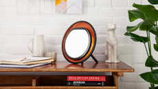 the lumie halo lamp sat on a wooden shelf with other art objects