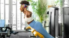 Woman using back extension machine in the gym