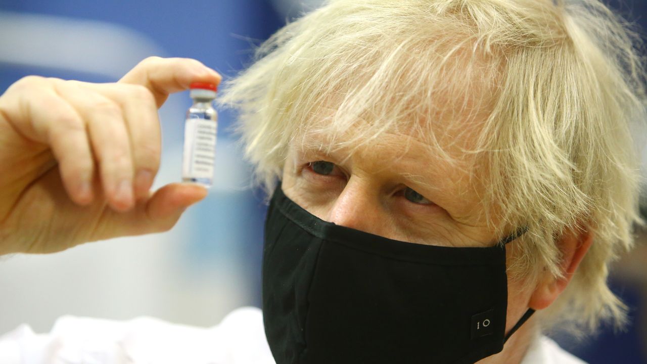 Boris Johnson poses with a vial of the Oxford-AstraZeneca vaccine