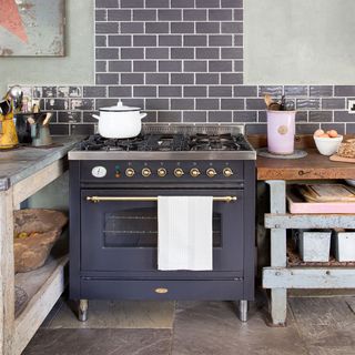 vintage style kitchen with grey cooker, metro tiles and wooden storage table