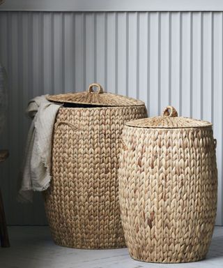 Two large water hyacinth storage baskets against grey wall boards