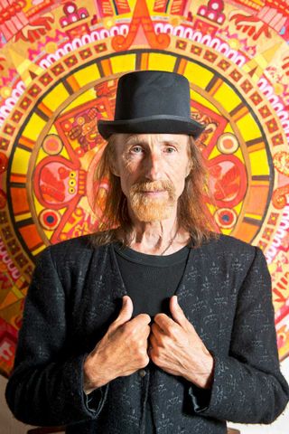 Arthur Brown standing against a psychedelic backdrop