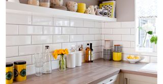 white kitchen with monochrome and yellow accessories to show a kitchen countertop organization idea using color