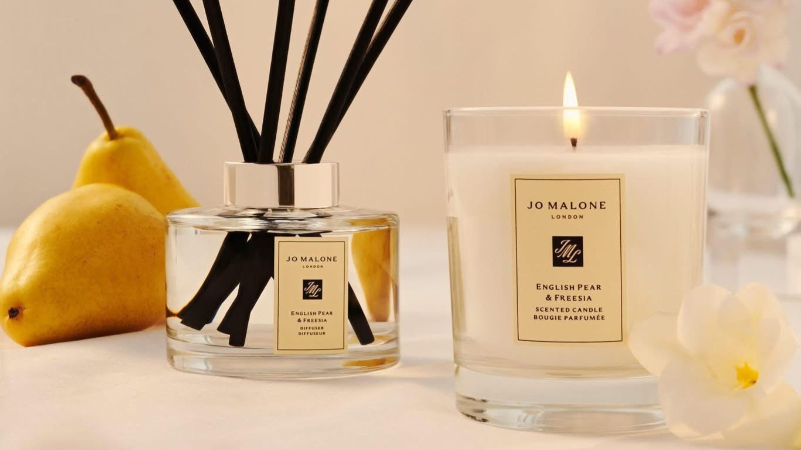 Jo Malone reed diffuser and candle with pear and freesia in background