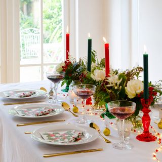 Christmas table setting with vases and candlesticks down the middle of the table