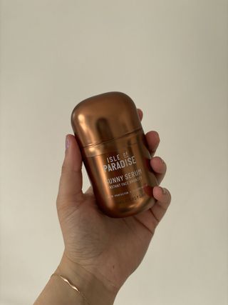 Mica holding a bottle of the Isle of Paradise Sunny Serum