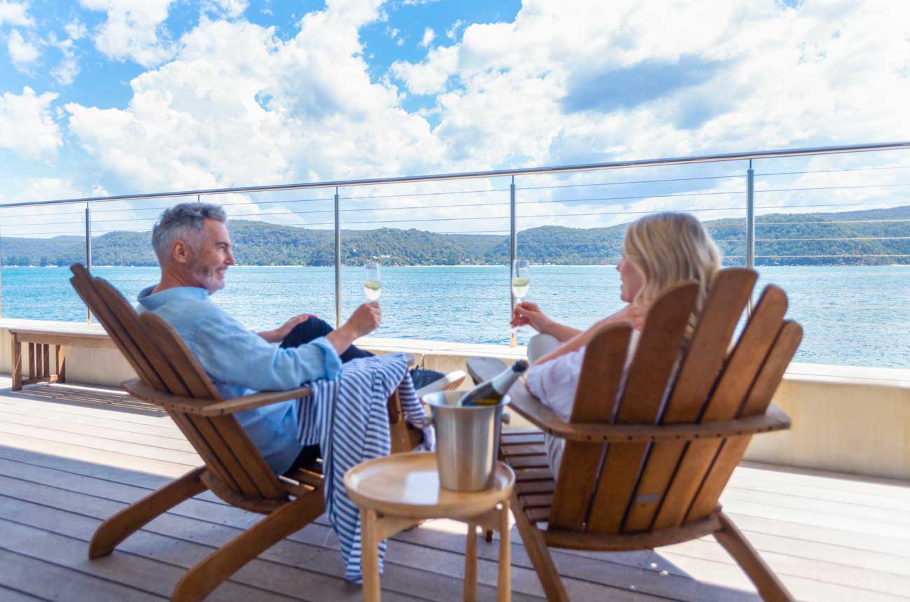 Image of couple on sun deck drinking sparkling wine.