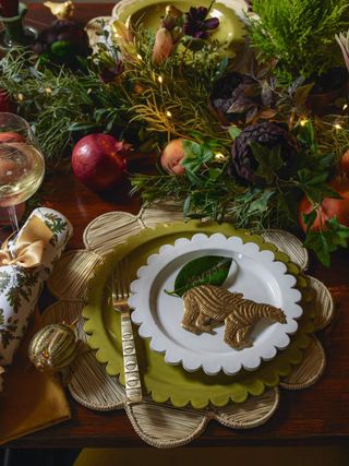 close-up of a Christmas dinner table place with a garland in the center that has fruits on it