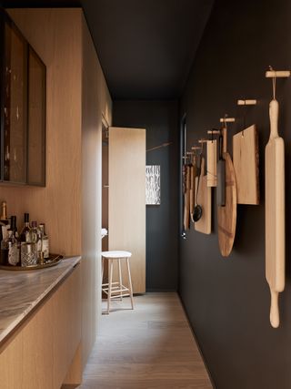 Pantry with black walls and wood features in the Edmonds + Lee house