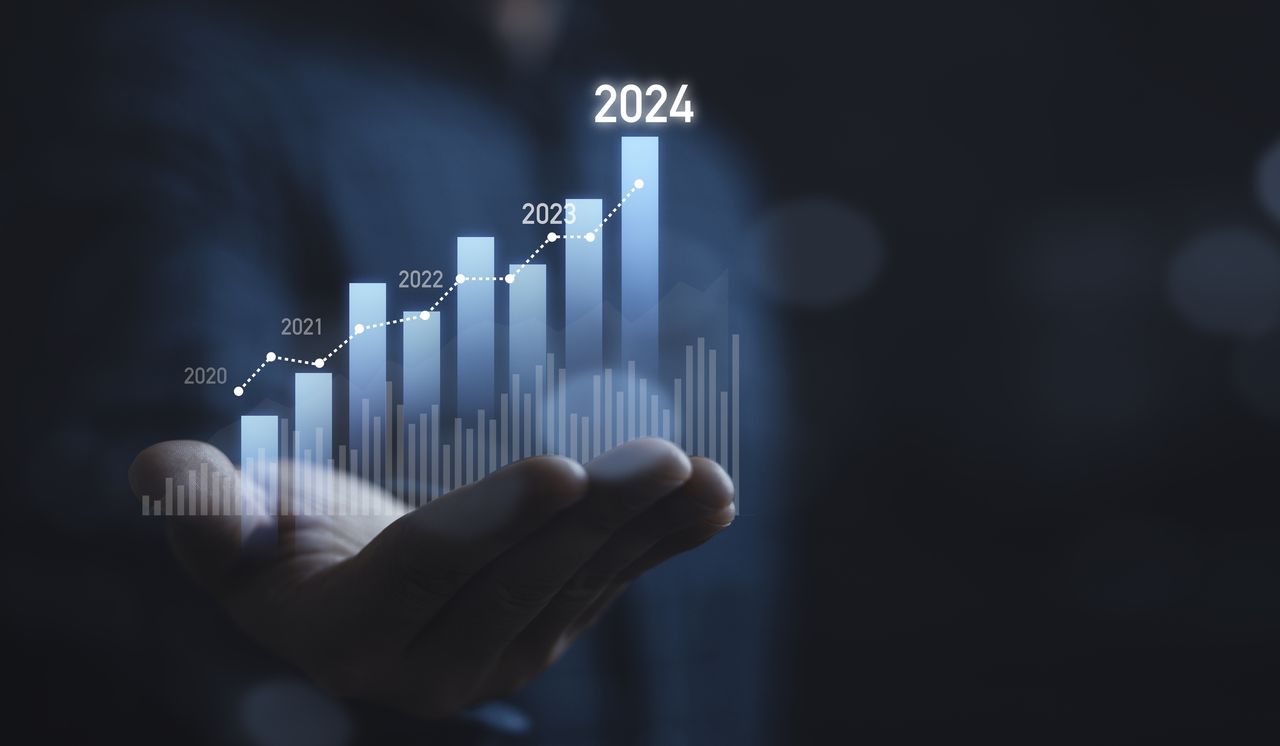 Businessman holding glowing virtual technical graph and chart for analysis stock market in 2024, technology investment and value investment concept.