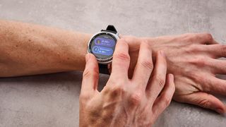 The Samsung Galaxy Watch 8 Classic on a man's wrist; he turns its dial to select its sleep features.
