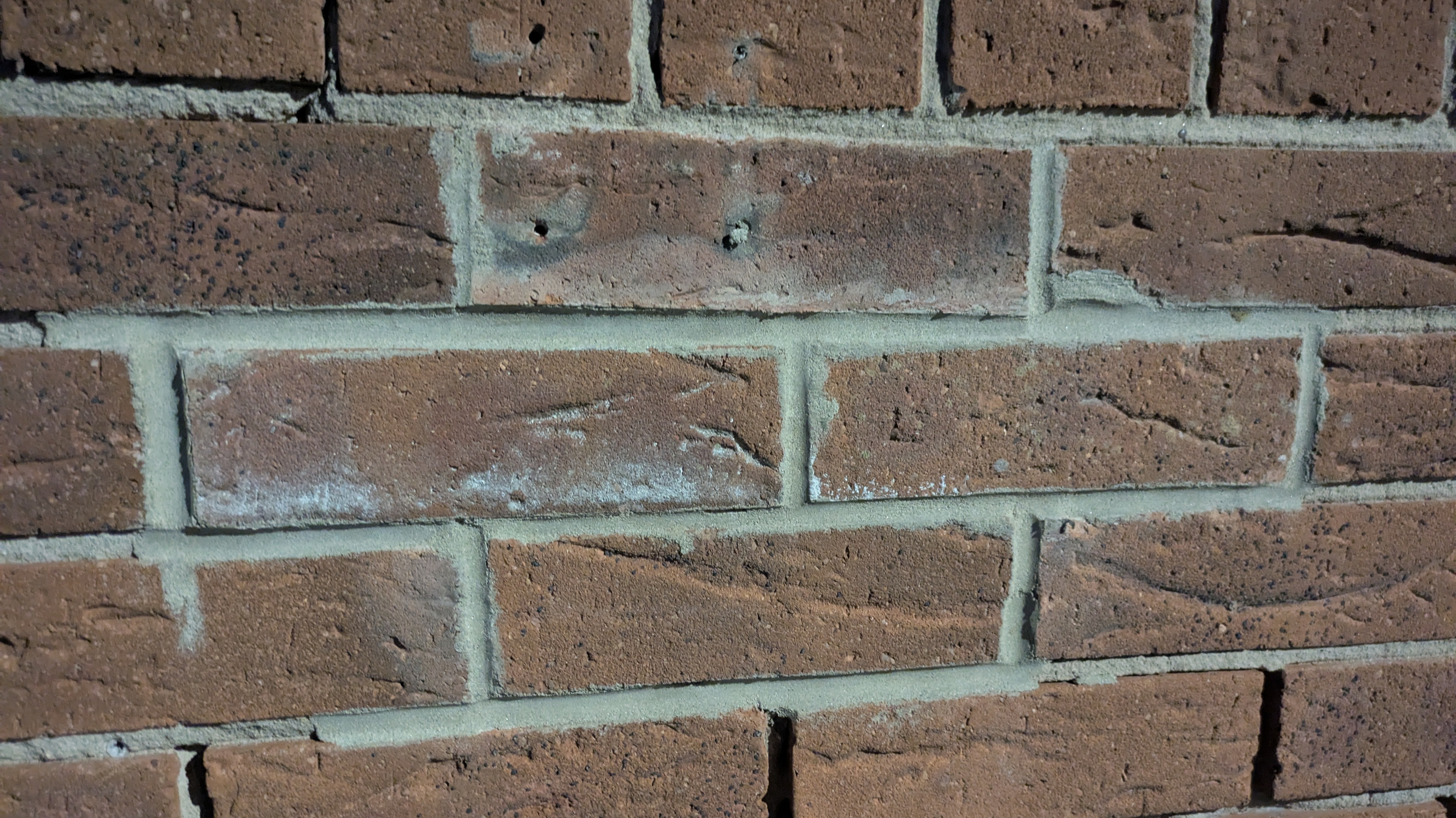 Some badly repointed brickwork with mess on the  brick faces and gaps in the joints