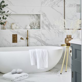 bathroom with marble tiled wall and white bathtub