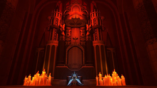 A red-lit alter with dozens of lit candles on the floor before it