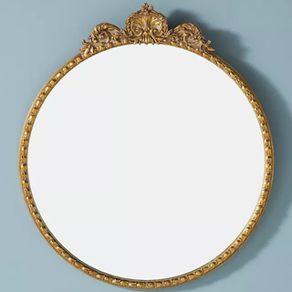 gold ornate circular mirror
